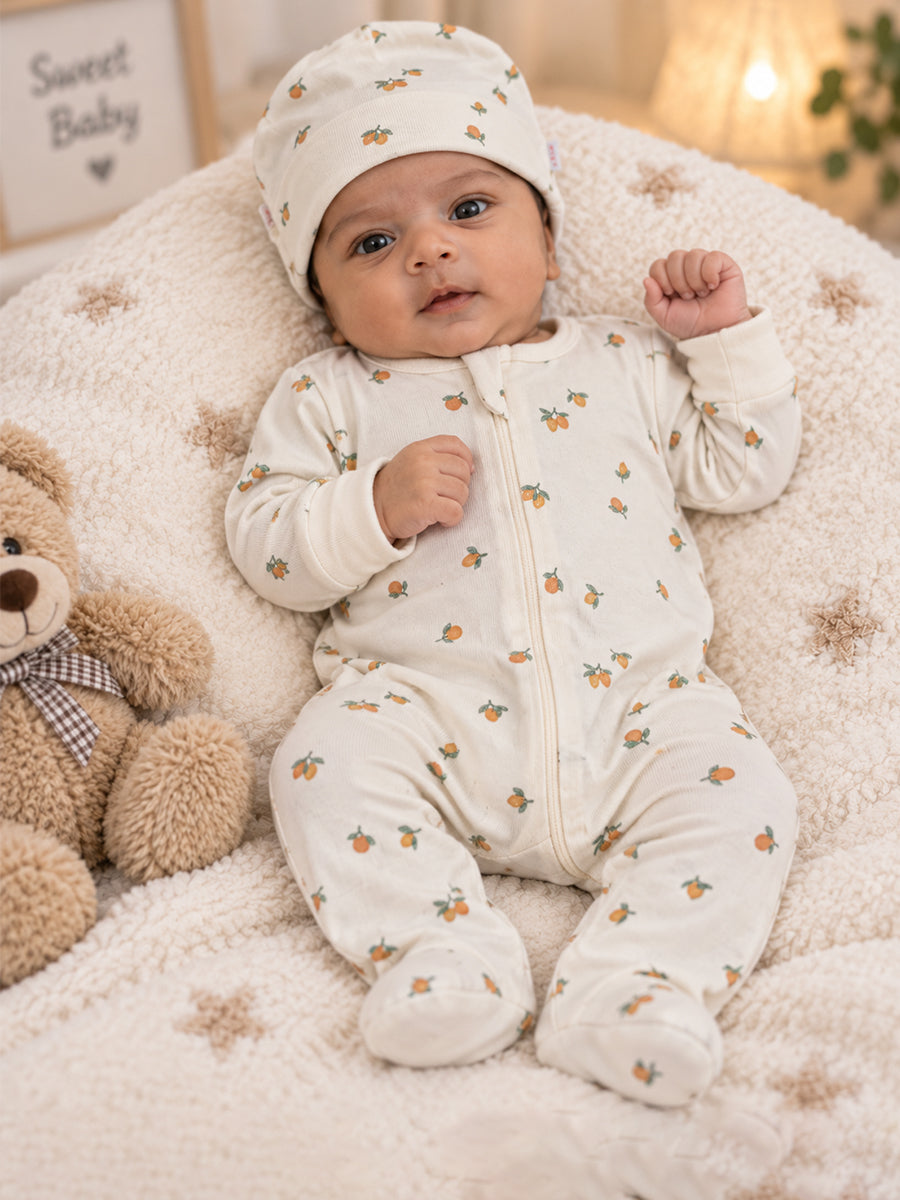 Ziva Baby Sleepsuit with Cap – Off White Tiny Orange Fruit Print | Premium Knitted Cotton | Front Zip | Fold-Over Mittens & Integrated Booties